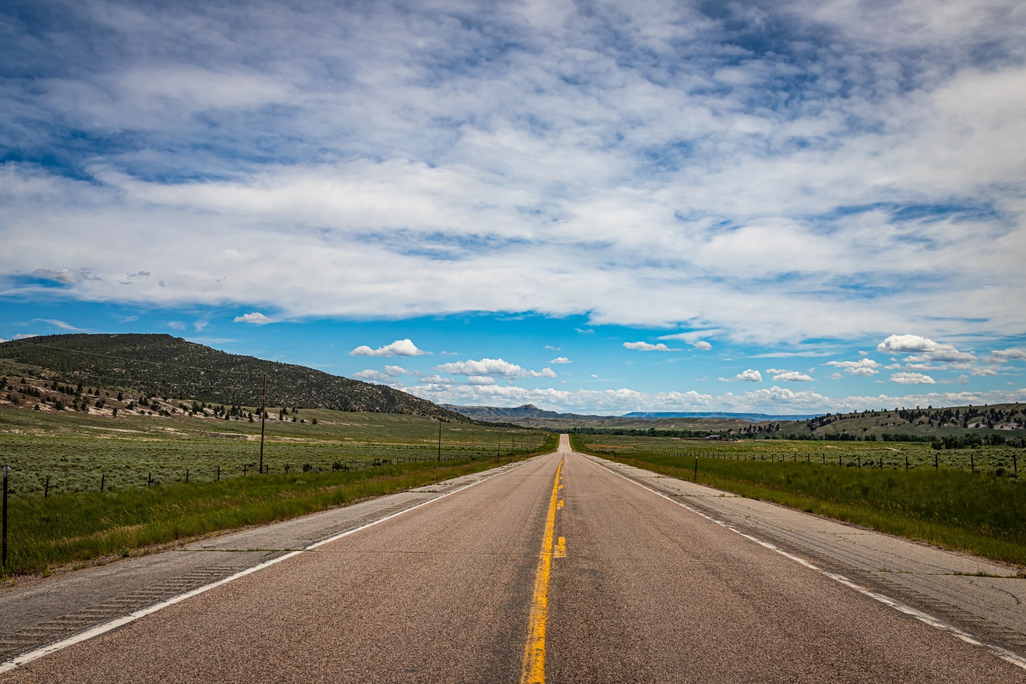 Open weg bij Casper in Wyoming met heuvels en blauwe lucht