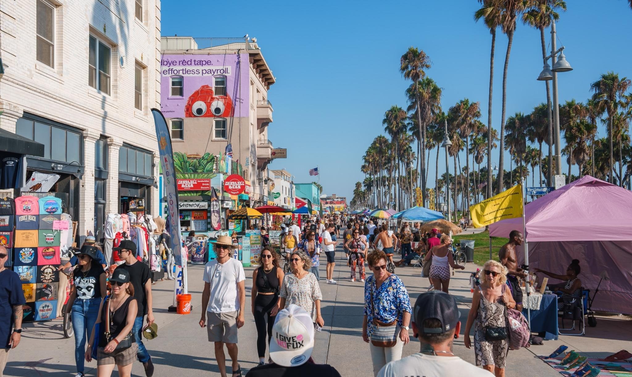 Drukke boardwalk Venice Beach met winkels en mensen
